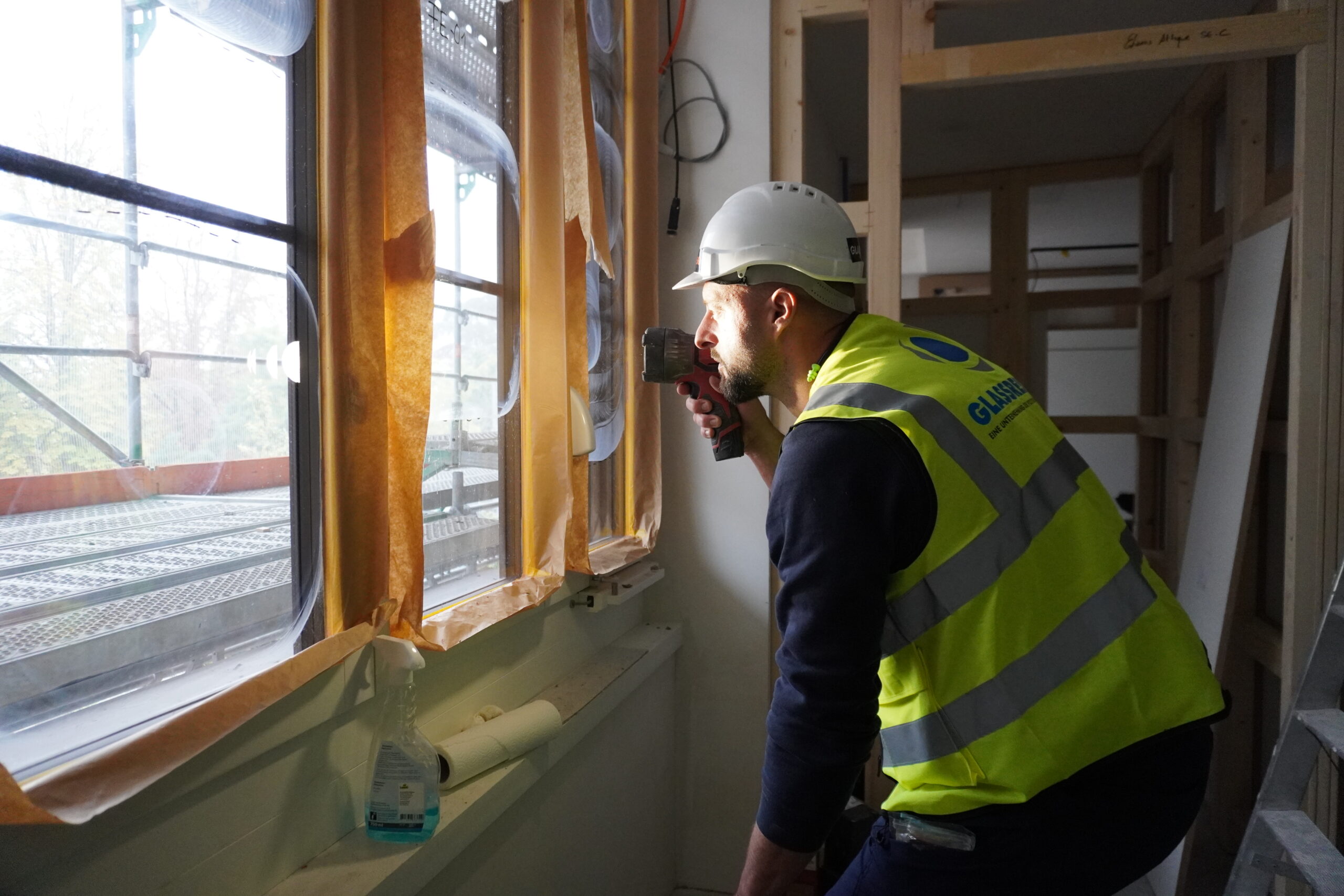 Auditeur énergétique inspectant les fenetres d'un bâtiment professionnel